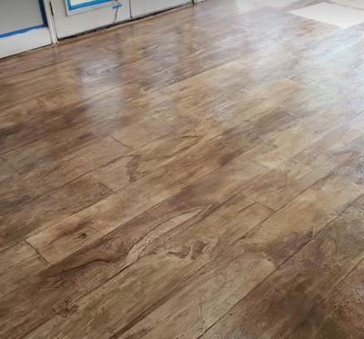 Concrete floor with brown wood color stain and hardwood stamp finish in Findlay hom