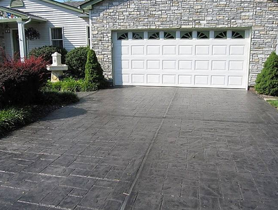 Grey colored stamped concrete driveway leading into two care garage of Toledo, Ohio home