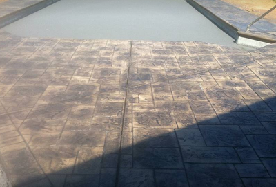Decorative concrete pool decking designed to appear as brick pavers in Toledo